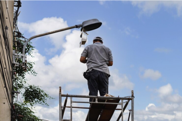 Electrician repairing streetlight.