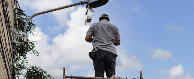 Electrician repairing streetlight.
